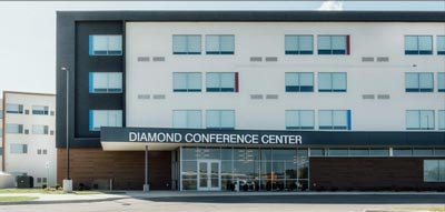 Exterior view of the Diamond Conference Center, a modern multi-story building with large windows and a flat overhang above the main glass entrance.